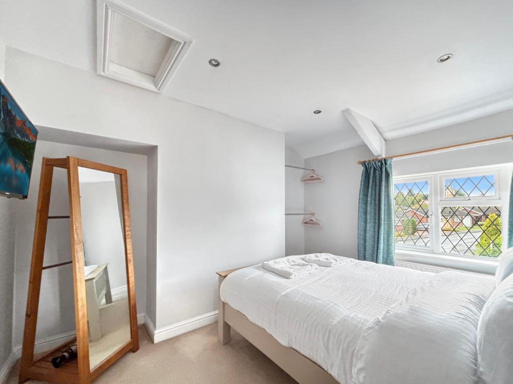 a bedroom with a bed and a mirror at Amaya Eleven - 3 bed cottage in village in Harlaxton