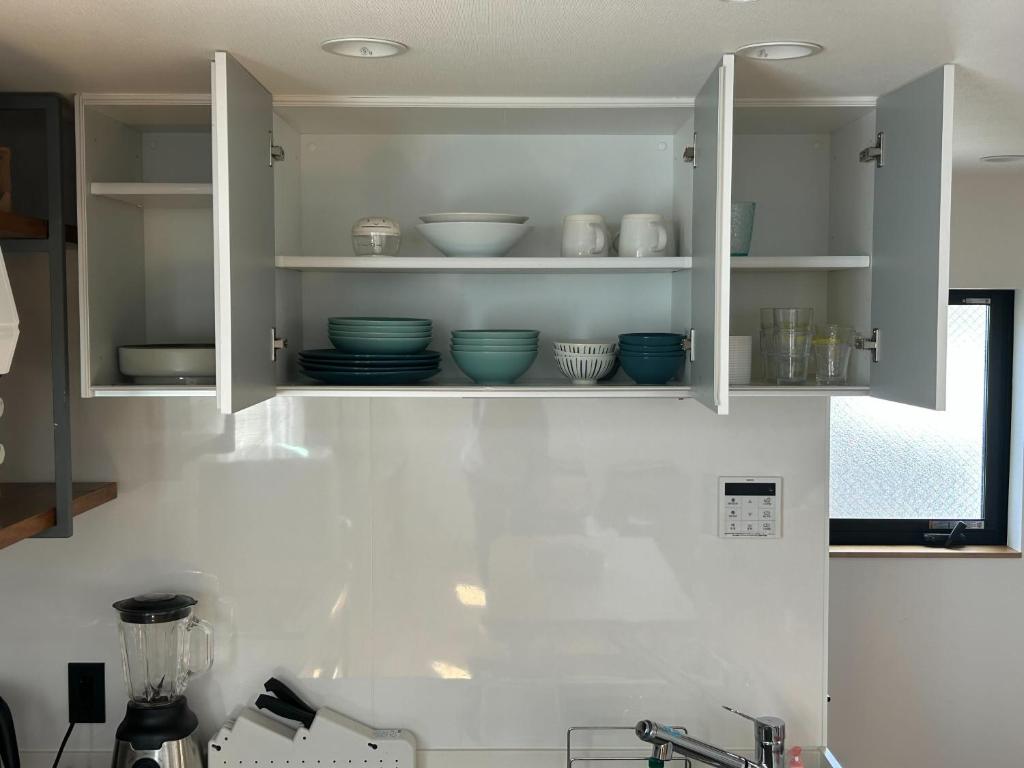 a kitchen cabinet with bowls and plates on it at Near JR Kameari Tokyo - Shades of Green - Japanese House for up to 6 Guests in Tokyo