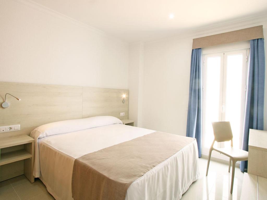 a bedroom with a bed and a desk and a window at AReH Apartamentos in Barbate