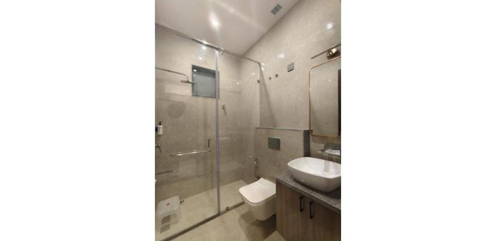 a bathroom with a sink and a glass shower at Shree Aaradhya Suites in Khātu