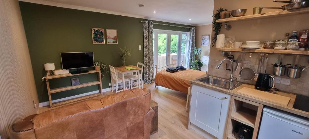 a kitchen and living room with a couch and a bed at Fern Studio in Lyme Regis
