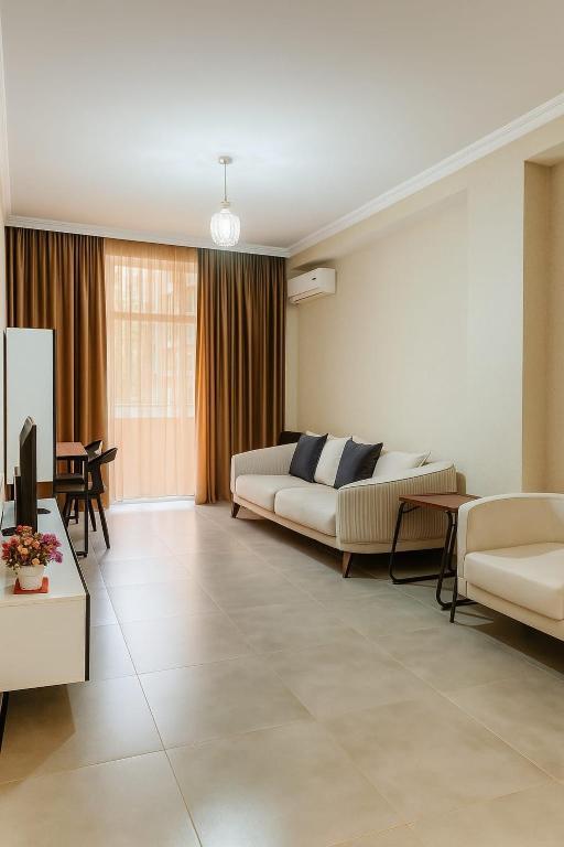 a living room with a couch and a table at Sweet Home Saburtalo in Tbilisi City
