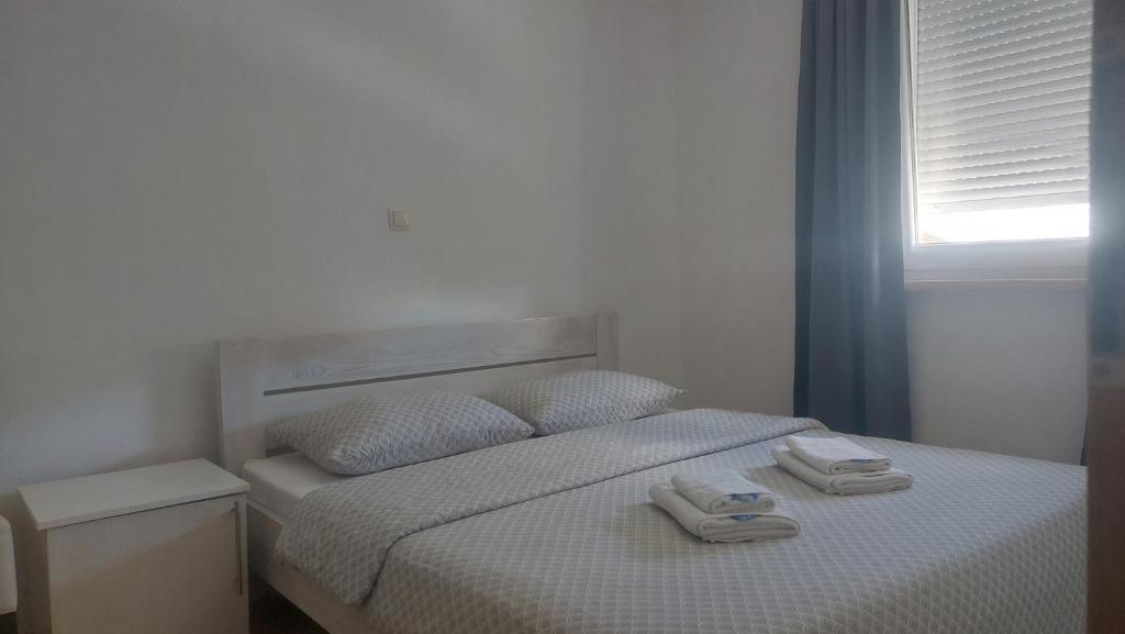 a bedroom with a bed with two towels on it at Apartman Mario in Tomislavgrad