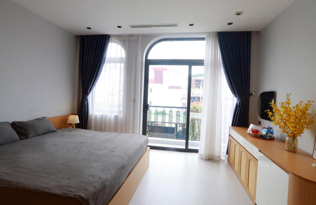 ハノイにあるValora Residence West lake - 31 Xuan Dieuのベッドと大きな窓のある寝室