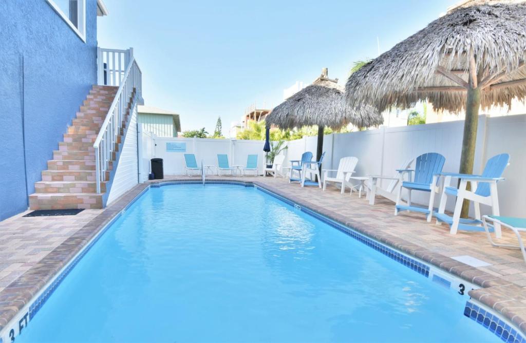 a swimming pool with chairs and umbrellas next to a building at Seagrass Flats in Ilexhurst