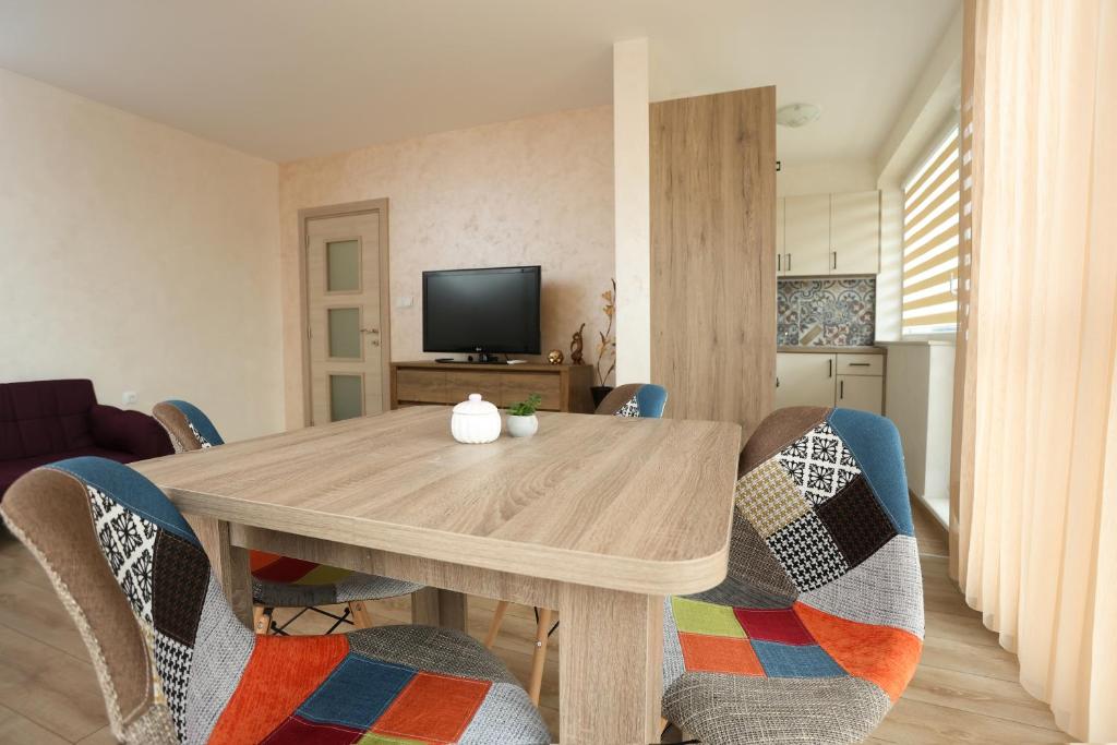 a living room with a wooden table and chairs at Апартамент за гости 2 Тракия Плаза in Shumen