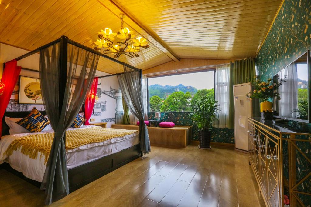 a bedroom with a bed and a large window at XI SHANG YUN JIAN Inn in Hanqiyu