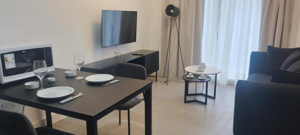 a living room with a table and a tv at Confort y Cercania Ezeiza in Ezeiza