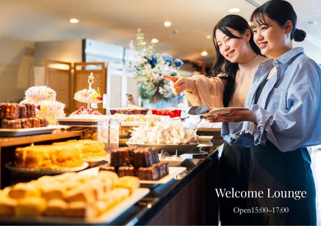 Deux femmes debout dans une boulangerie désignent des aliments dans l'établissement Shiragiku, à Beppu 42 autres photos