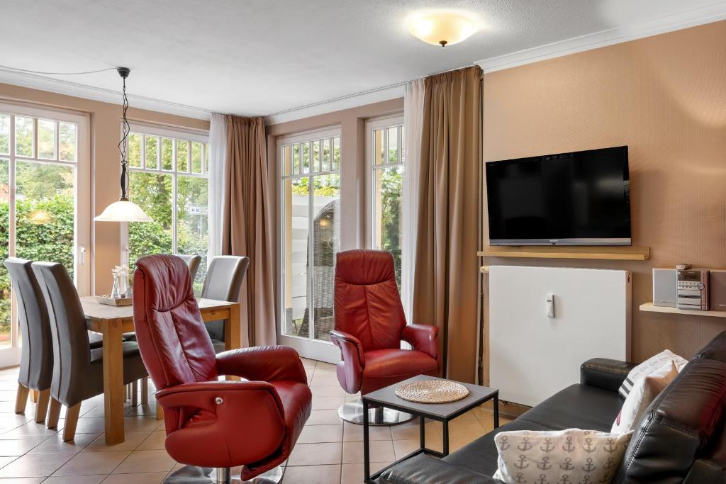 a living room with a couch and chairs and a tv at Dünenschloss Dünenschloss 2-05 in Kühlungsborn