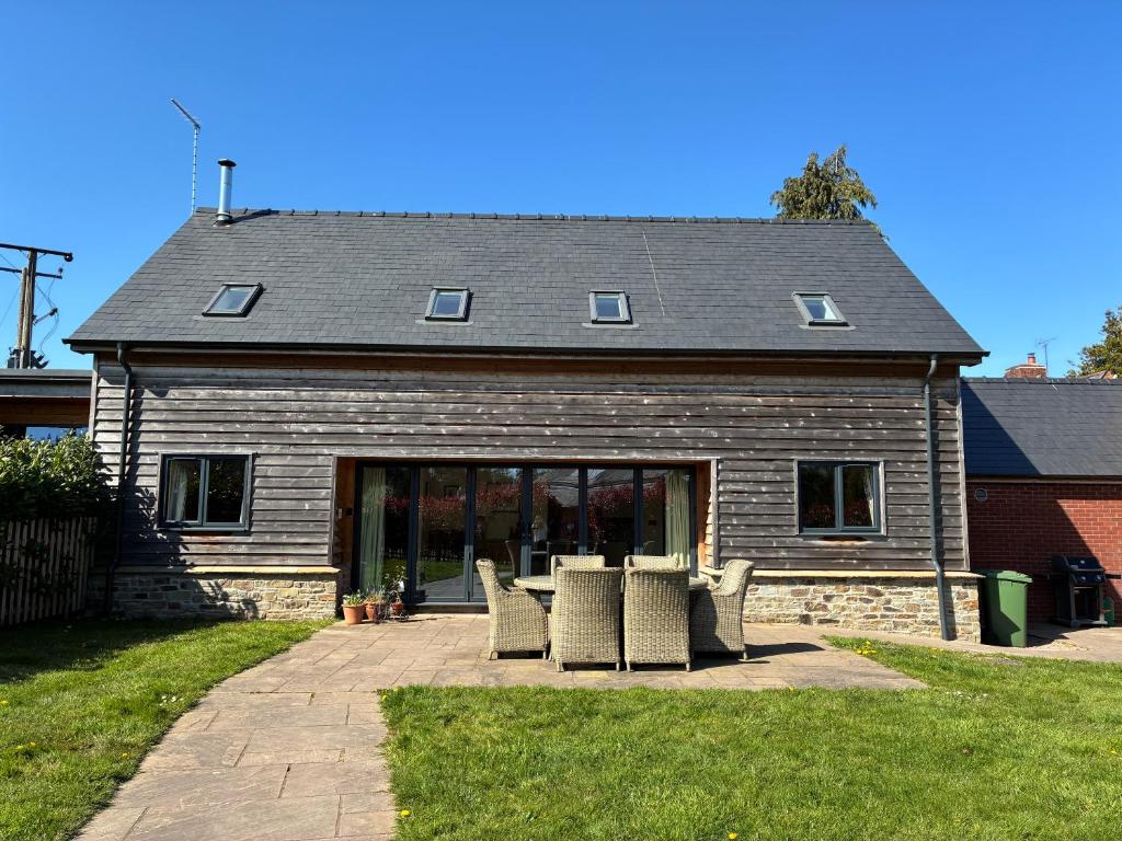 een huis met stoelen ervoor bij Meadow View House at Pudleston Court in Docklow