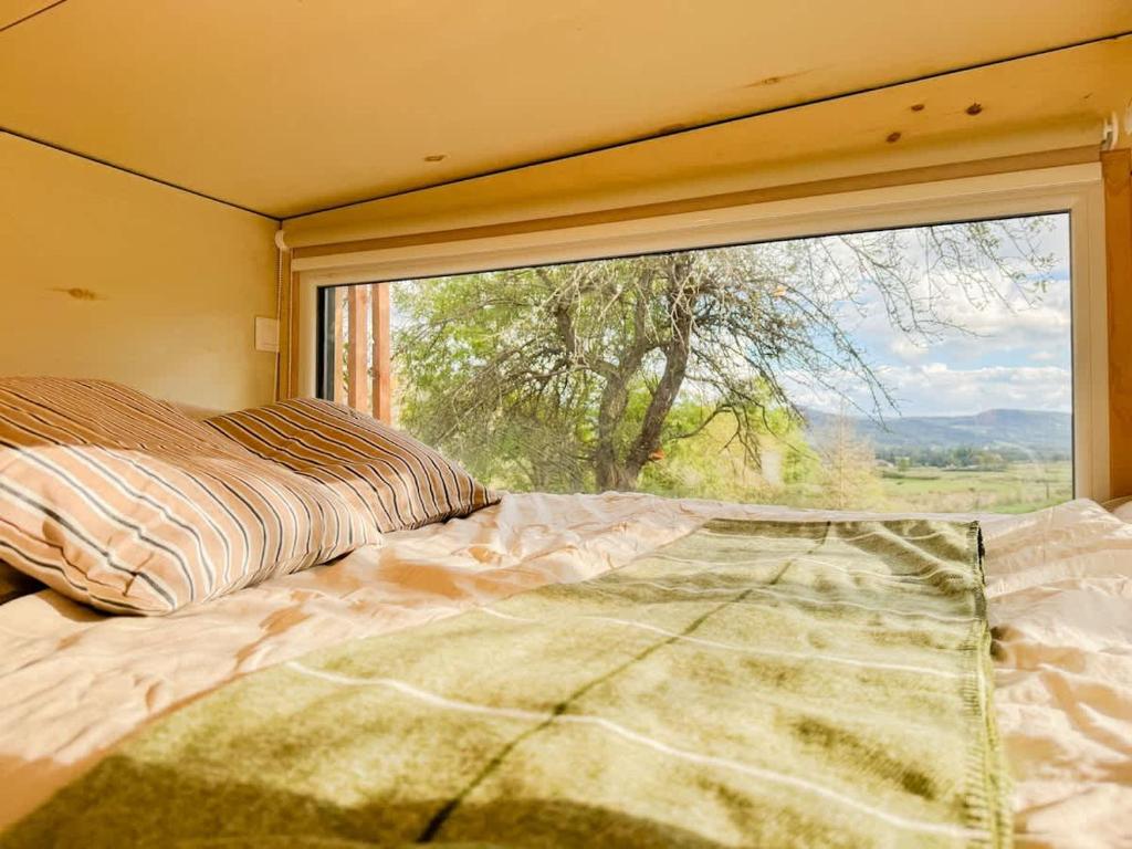 a bedroom with a bed and a large window at La Clairière de Peylenc - Refuge en Velay in Saint-Pierre-Eynac