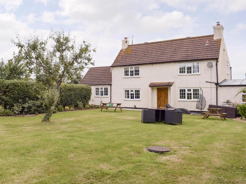 a white house with a picnic table in a yard at Glebe Farm Cottage in Hornby