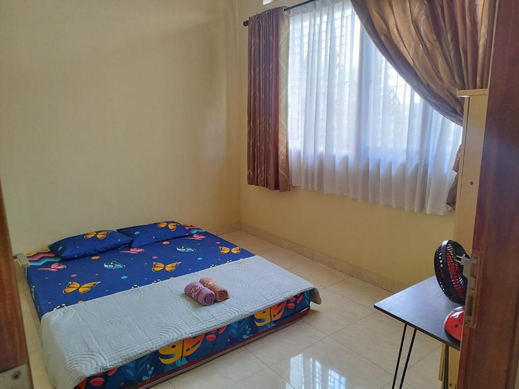 ein Schlafzimmer mit einem Bett mit zwei Stofftieren darauf in der Unterkunft Omah Semaki in Demangan