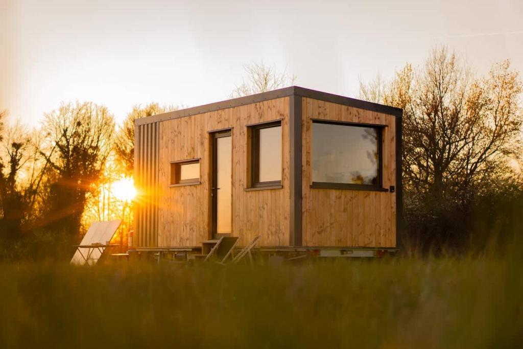 a tiny house in a field with the sun setting at L'Échappée Royale - Beauval et Route des Châteaux in Billy