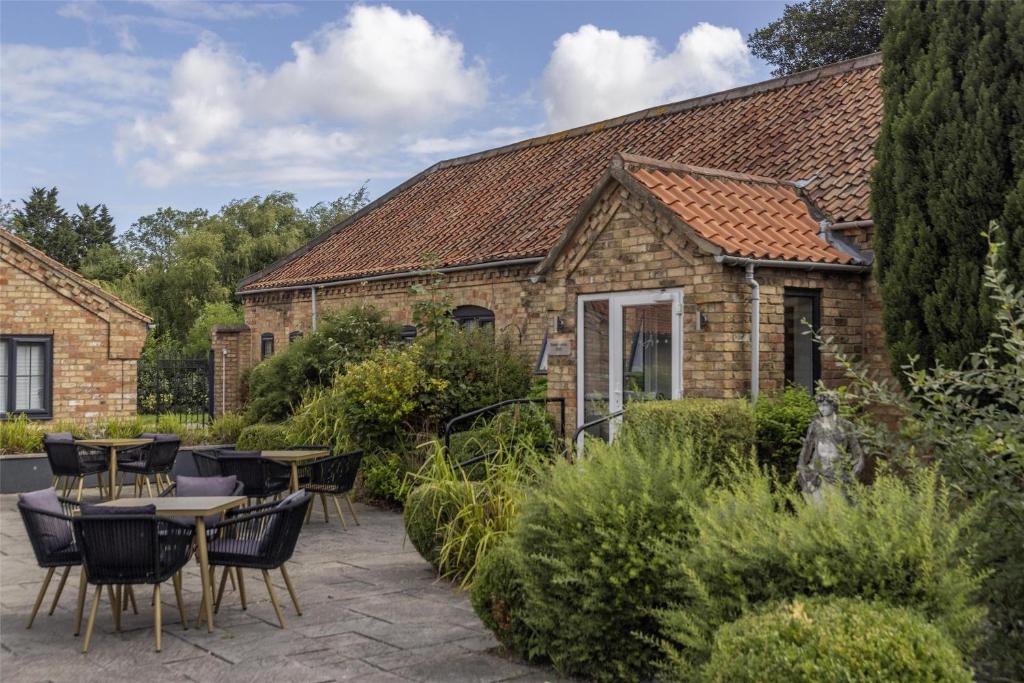 a patio with tables and chairs in front of a building at The Ashbourne Hotel, BW Signature Collection in North Killingholme