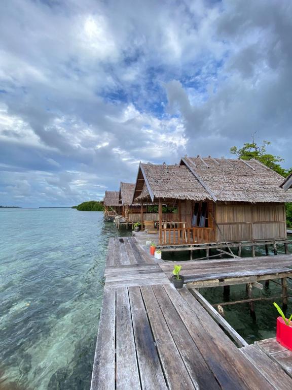 a row of huts on a dock in the water at Senjahomestayrajaampat in Fam