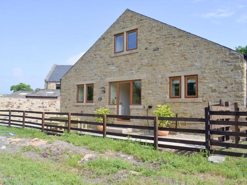 a stone house with a fence in front of it at The Old Dairy - Ukc3413 in Bolton by Bowland