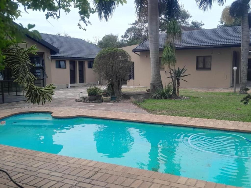 a swimming pool in front of a house at Nqabanqaba 12 in Meer en See