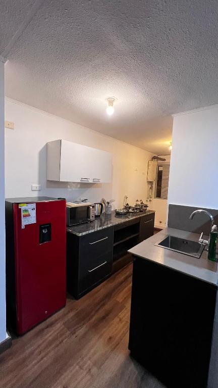 a kitchen with a red refrigerator in a room at Escapadas Elqui Departamento en La Serena in La Serena