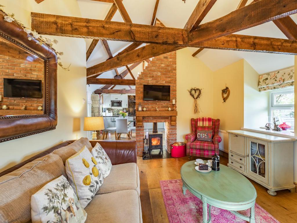 un soggiorno con un divano e un tavolo di Cowslip Cottage a Swarland