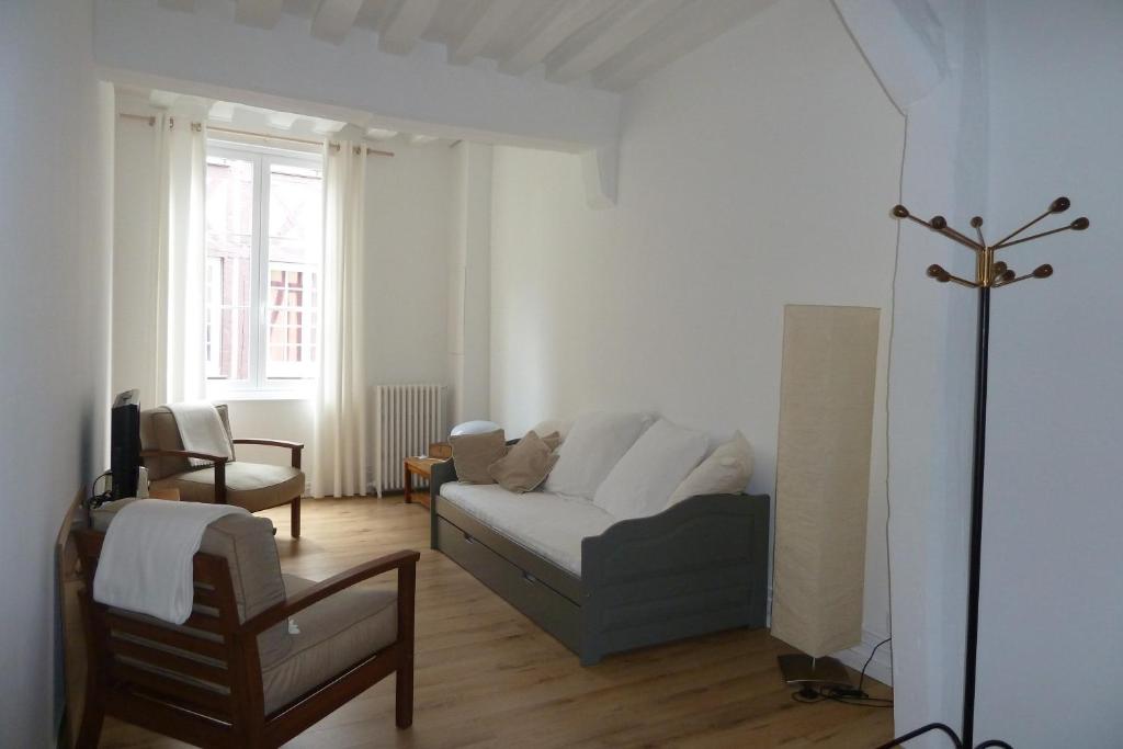 a living room with a couch and a chair at Une Chambre Dans L'atelier De R in Rouen