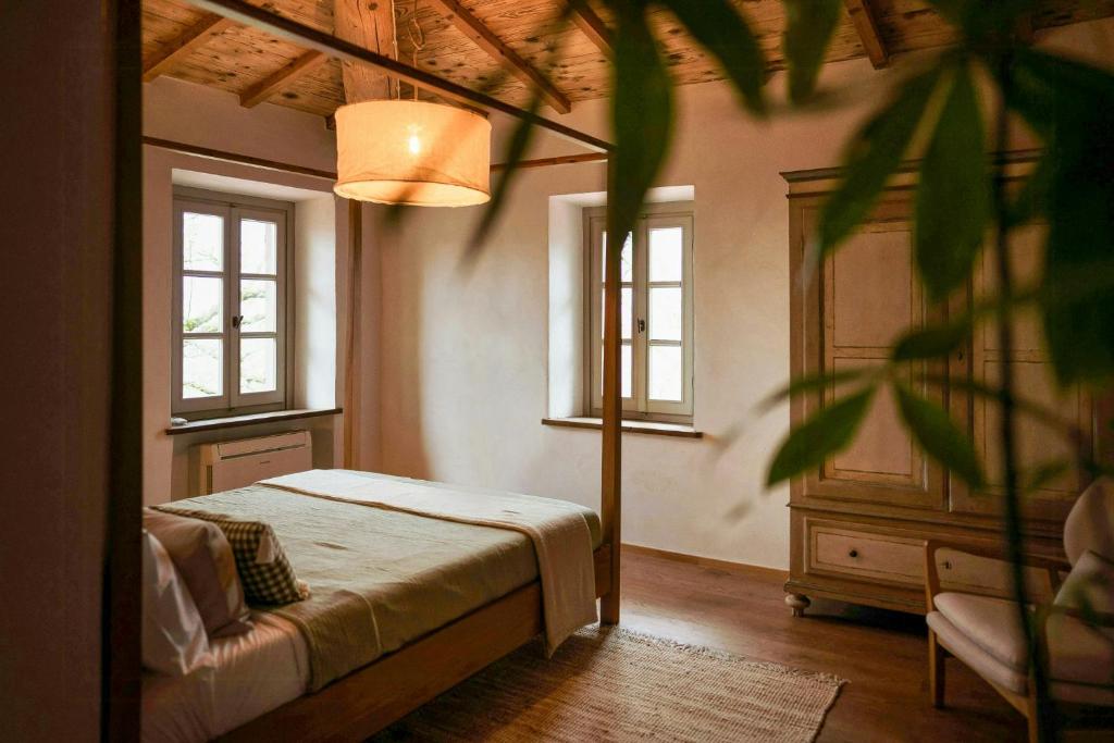 a bedroom with a bed and two windows at Stone Villa With Panoramic Pool in Bibbiena