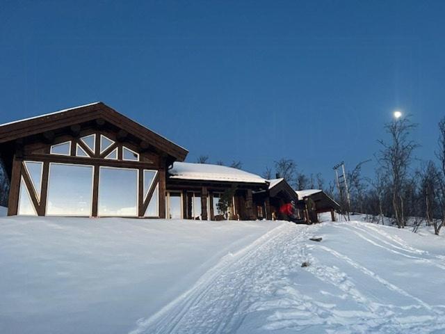 ein Gebäude mit Schnee auf dem Boden davor in der Unterkunft Log Cabin With Panoramic Views Of Hallingskarvet in Hovet