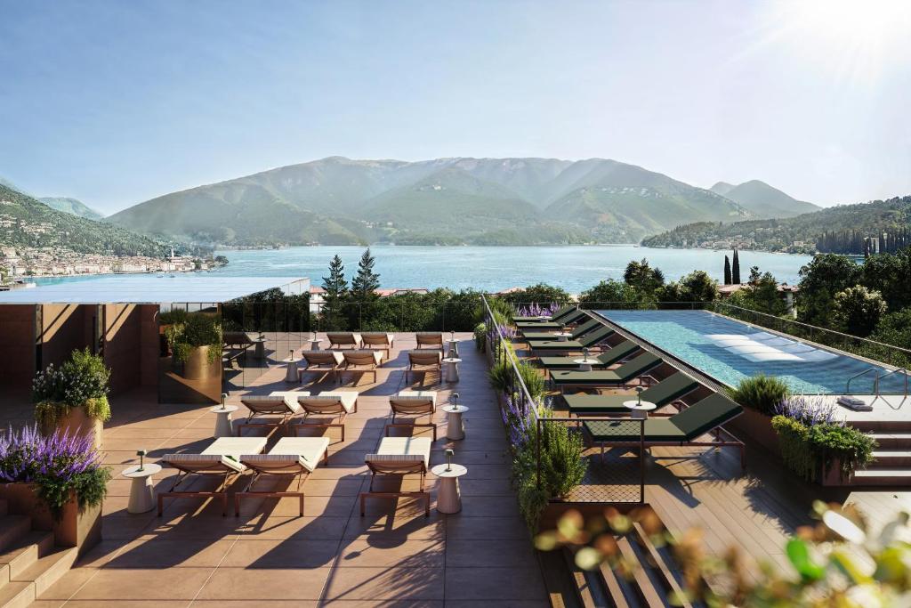 uma fila de mesas e cadeiras junto a uma piscina em Falkensteiner Resort Lake Garda em Salò