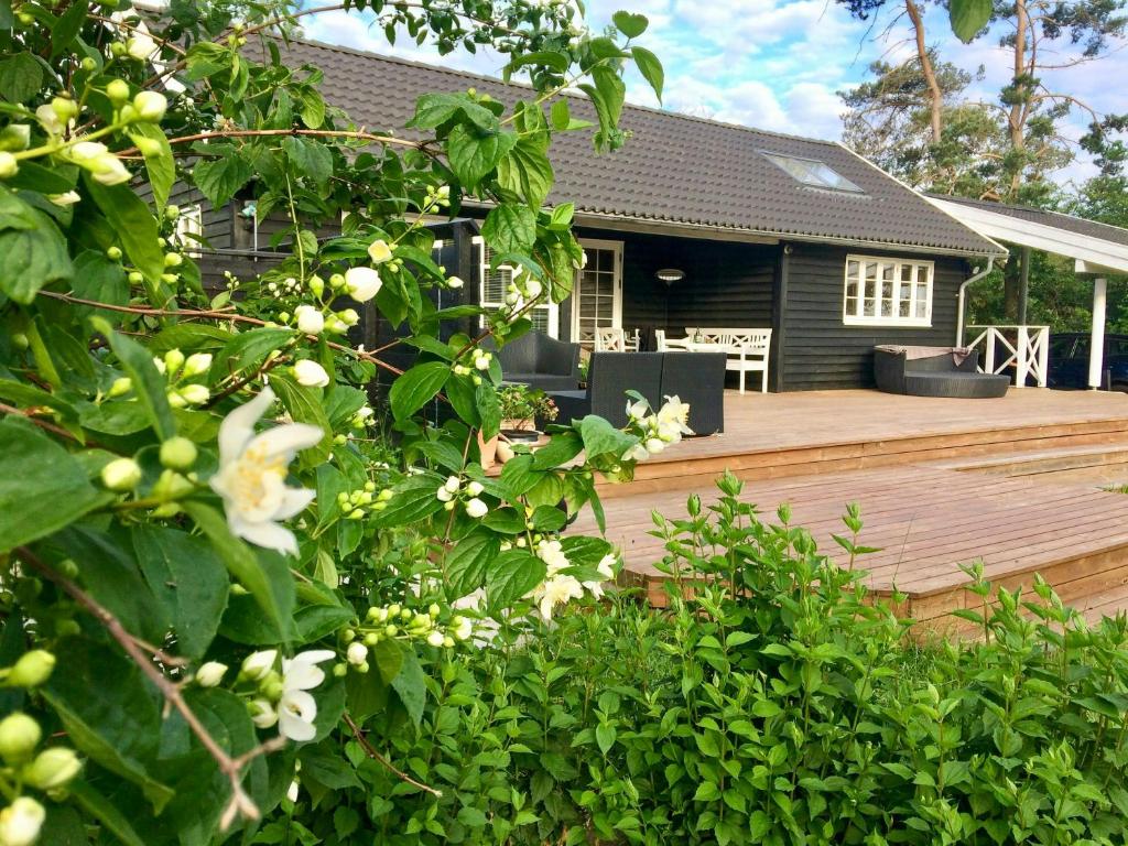 ein Hof mit einer Holzterrasse mit einem Haus in der Unterkunft Holiday Home By Viking Grave And Protected Nature in Korsør