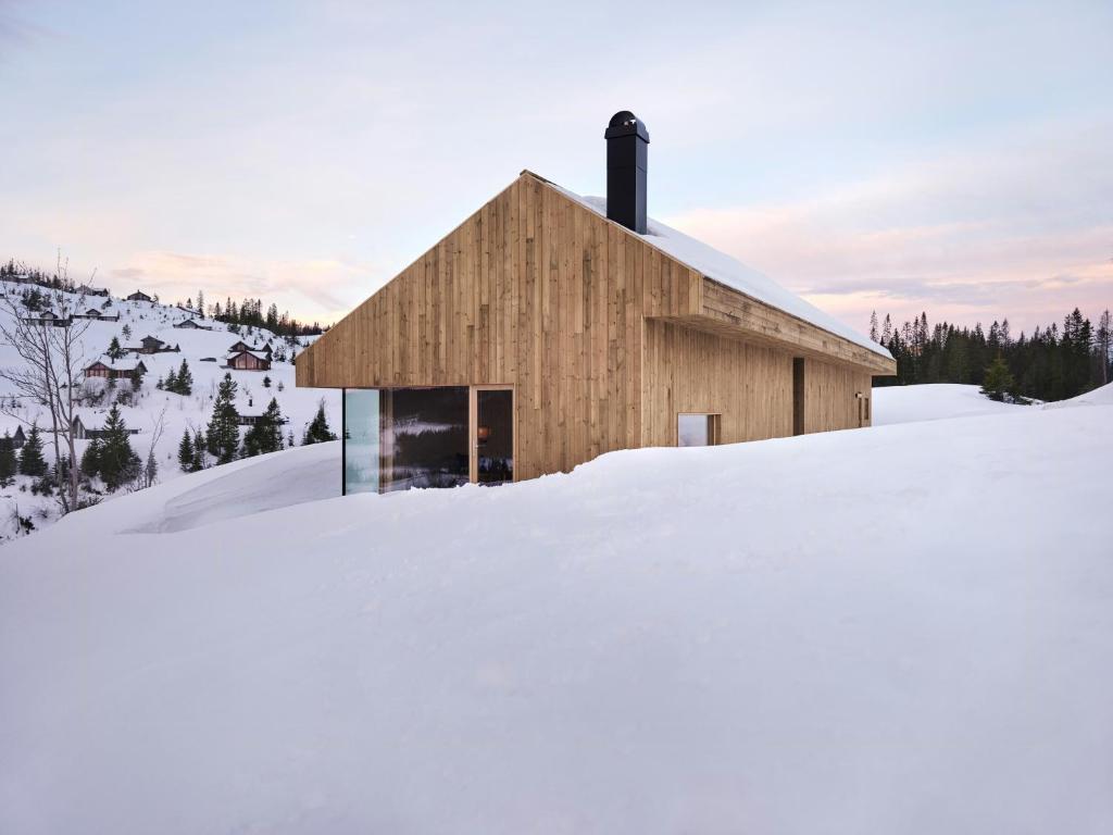 a building in the snow in front at Architect-Designed Cabin With Lake Mylla Views in Roa