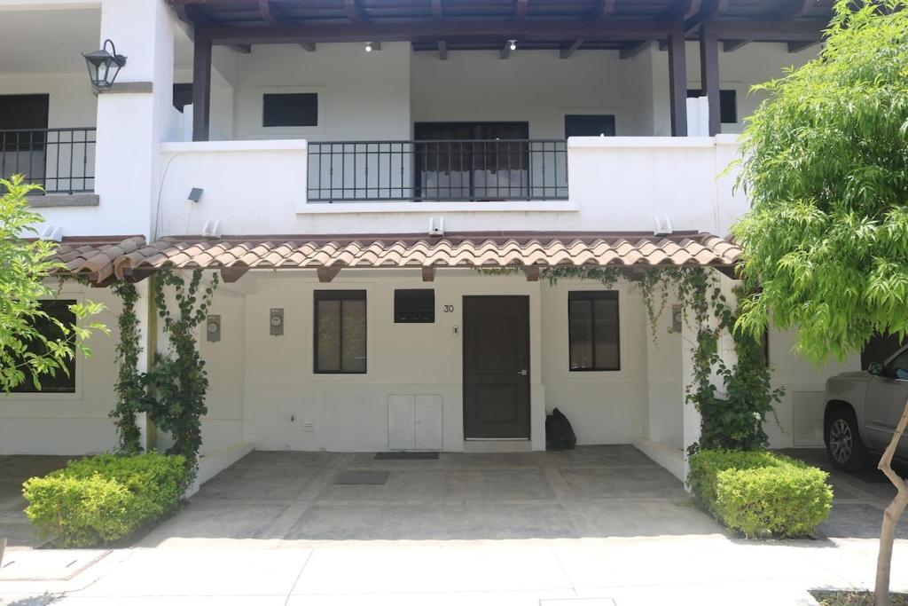 ein weißes Haus mit einem Tor und einer Auffahrt in der Unterkunft Mi Casita San Miguel in San Miguel