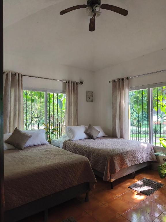 a bedroom with two beds and a ceiling fan at Melany's House's in Ajaxá