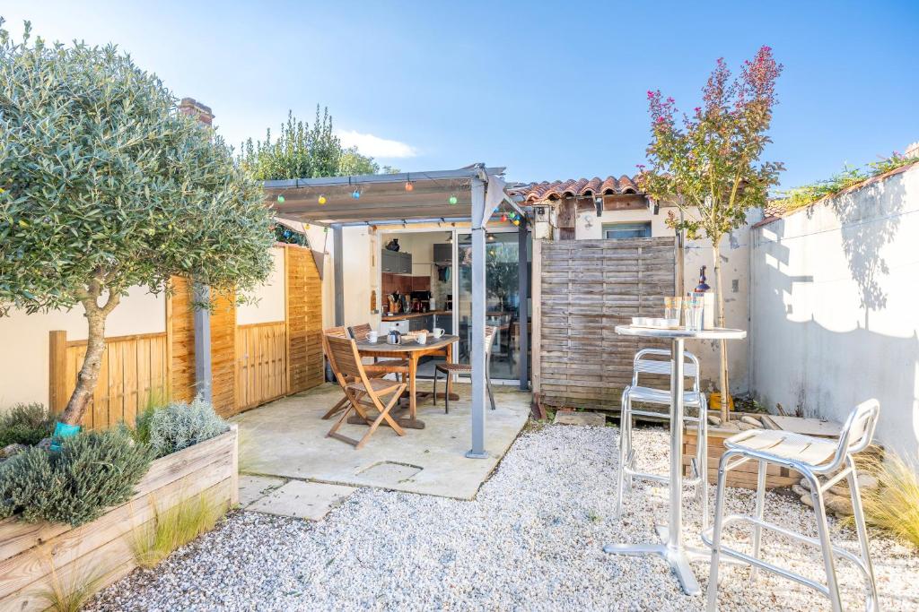 un patio con tavolo e sedie in un cortile posteriore di Maison proche de la mer a Longeville-sur-Mer