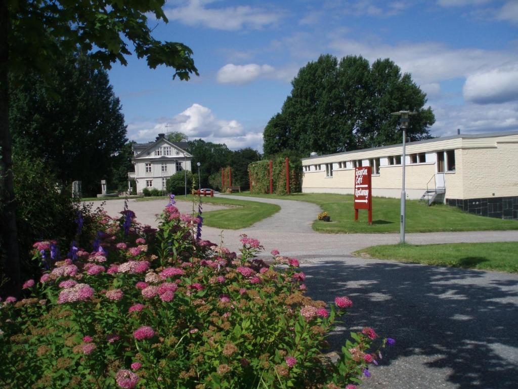 uma estrada que leva a um edifício com flores em Åkerby Herrgård em Nora