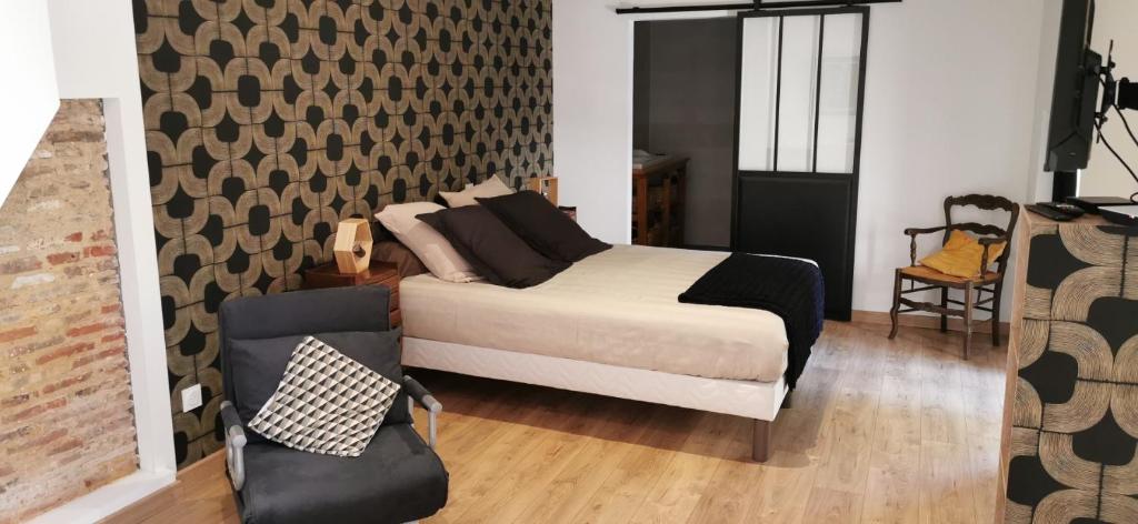 a bedroom with a king sized bed and a chair at Carpe Diem in Saint-Savin-sur-Gartempe
