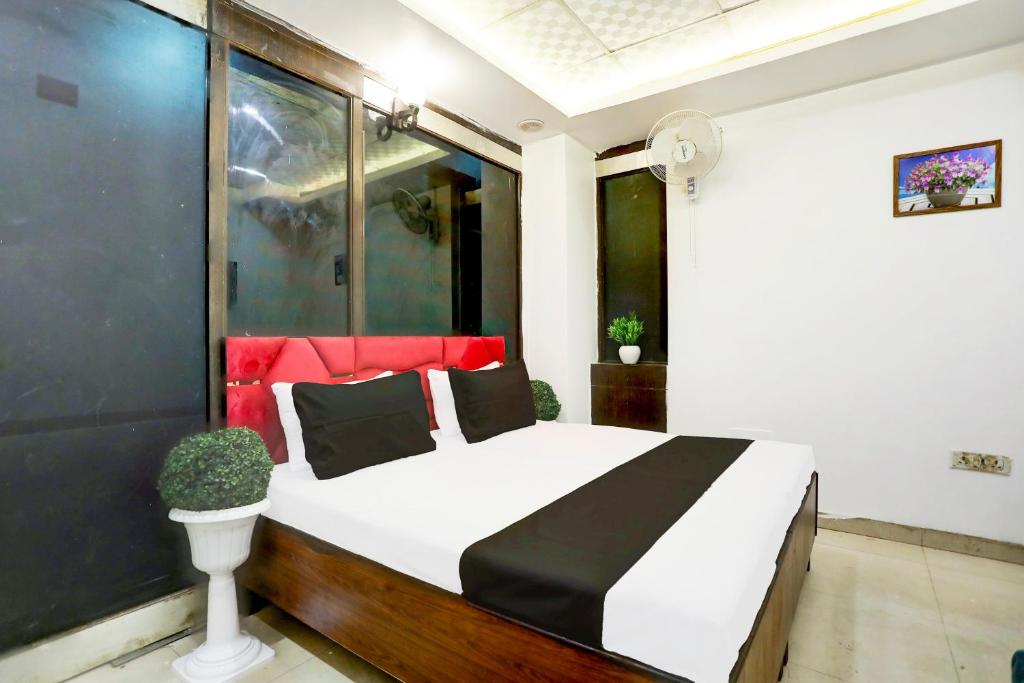 a bedroom with a white bed with a black and red headboard at Hotel O Kashish Residency in New Delhi
