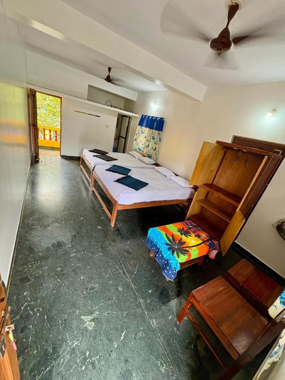 a bedroom with a bed and a chair in it at RadhaKrishna Stay IN in Arambol