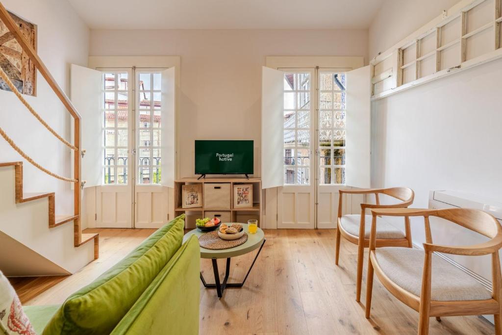 a living room with a green couch and a table at Heritage Loft I in the Cradle of Portugal by Portugal Active in Guimarães