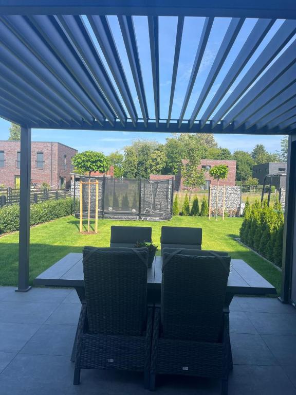 a patio with a table and chairs under a pergola at Ferienhaus am Lankower See in Schwerin