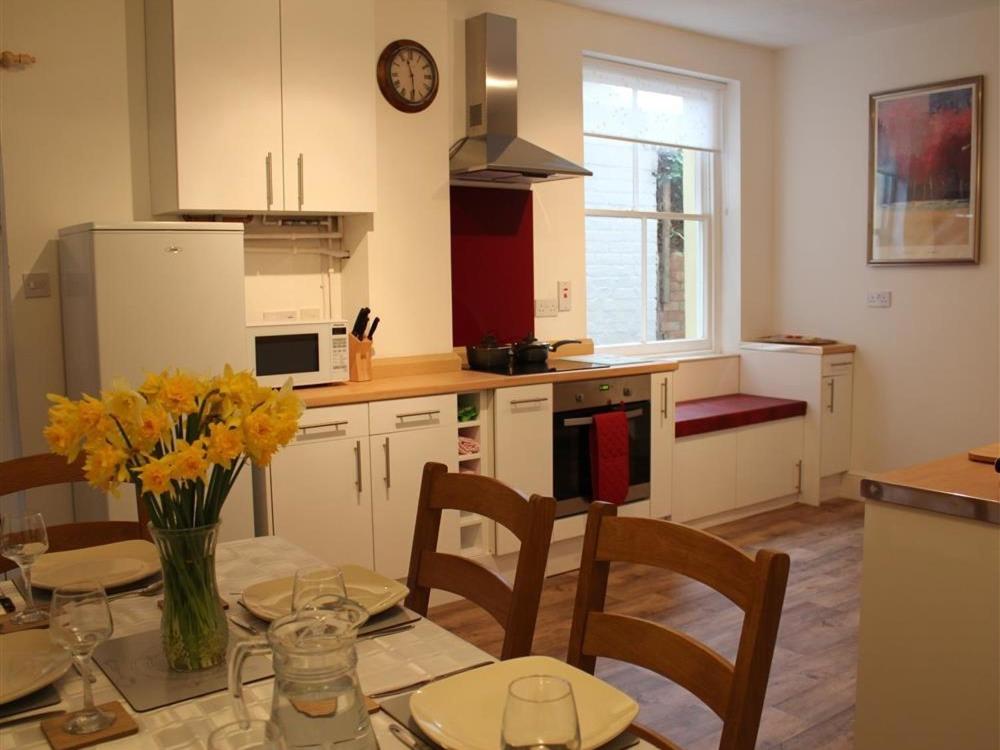 - une cuisine avec une table ornée de fleurs jaunes dans l'établissement Rojoy, à Salisbury