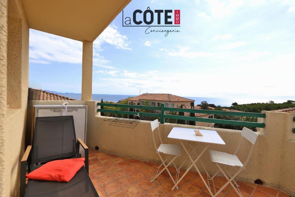 een terras met een tafel en stoelen op een balkon bij Ciel et mer in Sausset-les-Pins