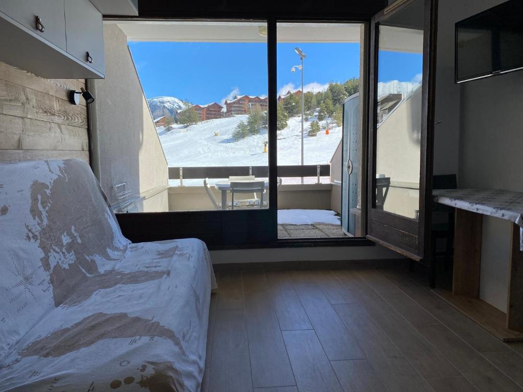 a room with a bed and a view of a ski slope at Studio 4 personnes, La Lauziere, La Joue du loup in La Joue du Loup