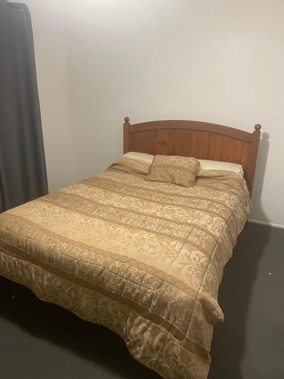 a bed in a bedroom with a wooden headboard at scarborough QLD private accommodation in Scarborough