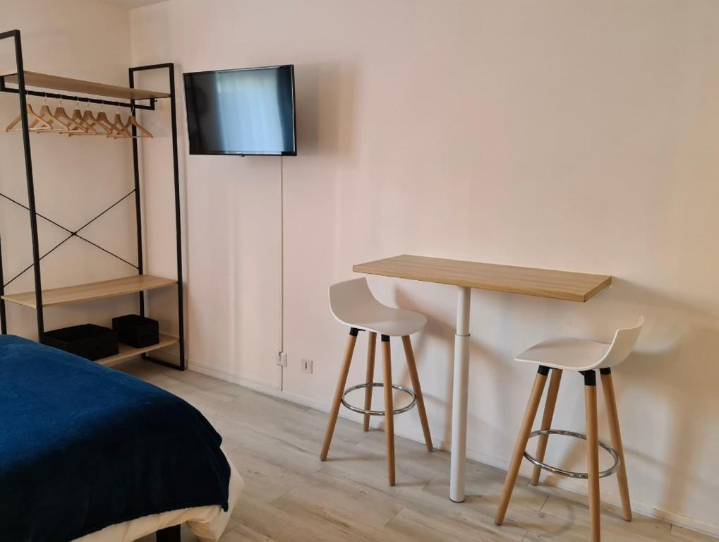 a bedroom with a table and two stools and a bed at Charmant studio, hypercentre de St Brieuc in Saint-Brieuc