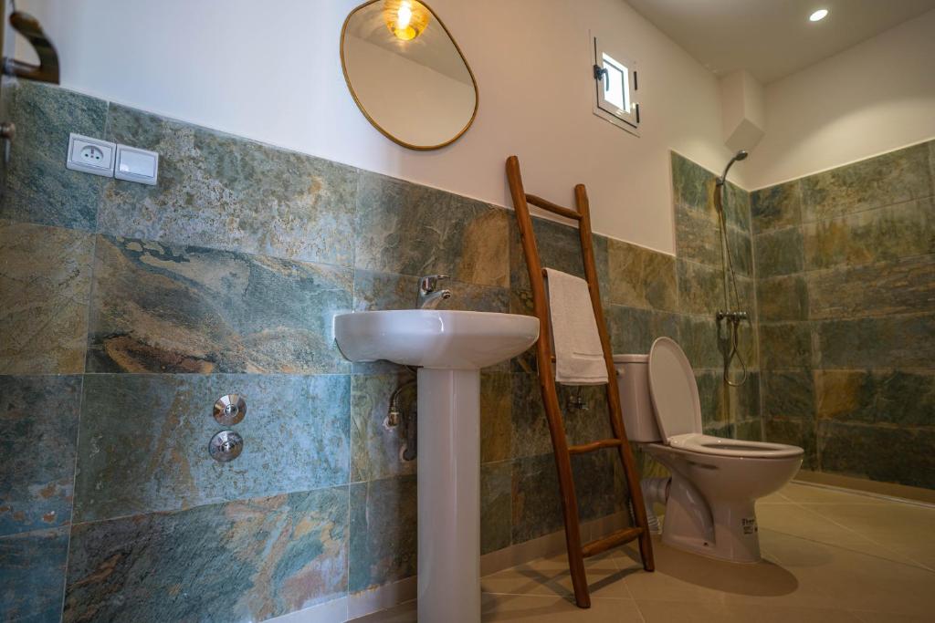 a bathroom with a sink and a toilet and a mirror at Riad TAWALA Surfing Mind in Tamraght Ouzdar