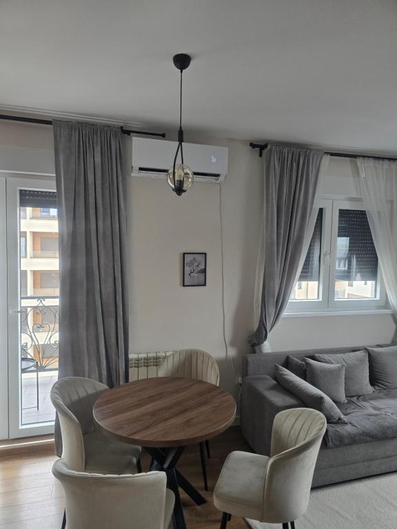 una sala de estar con un sofá, una mesa y sillas en Apartman I&N, en Zlatibor