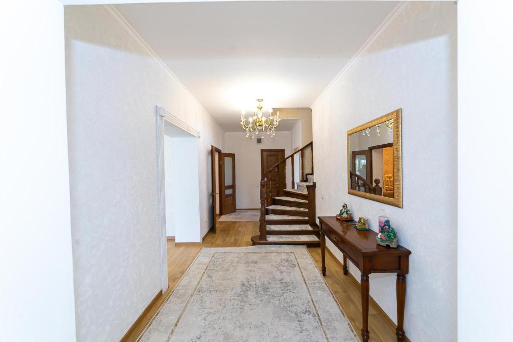 a hallway with white walls and a chandelier at Er Targyn 19 in Astana