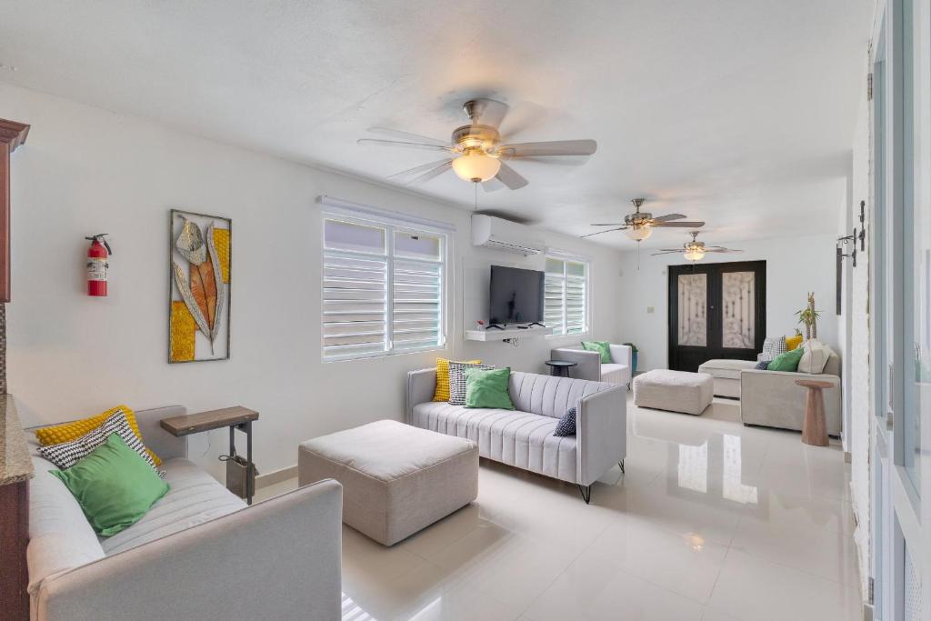 a living room with white furniture and a ceiling fan at Hacienda M&B Perfect for Groups, with Pool and Spacious Patio in Vega Baja