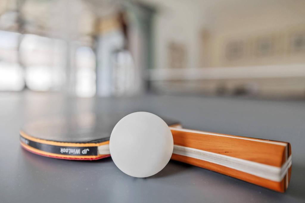 a ping pong racket and ball on a table at Family Retreat with Heated Pool, Playground, Ping Pong Table in Jasmine Estates